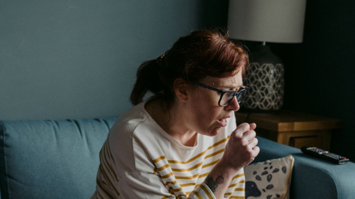 woman in white crew neck t-shirt sitting on gray sofa