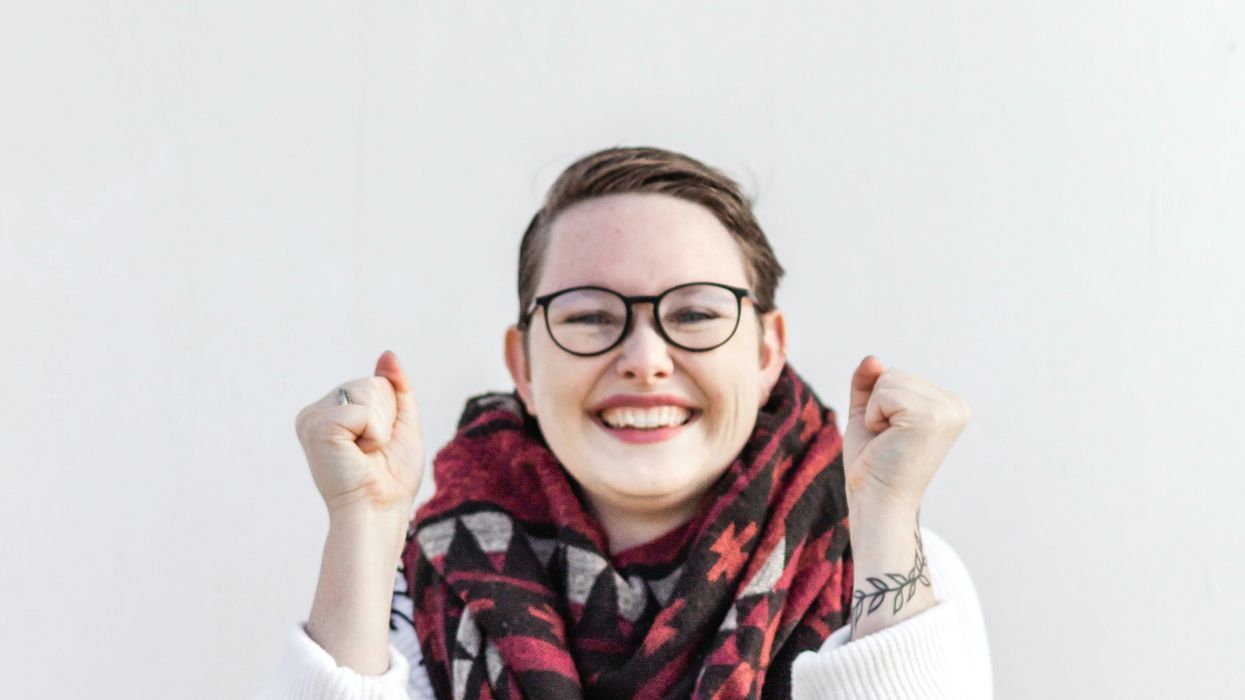 woman in white sweater wearing red scarf and black framed eyeglasses