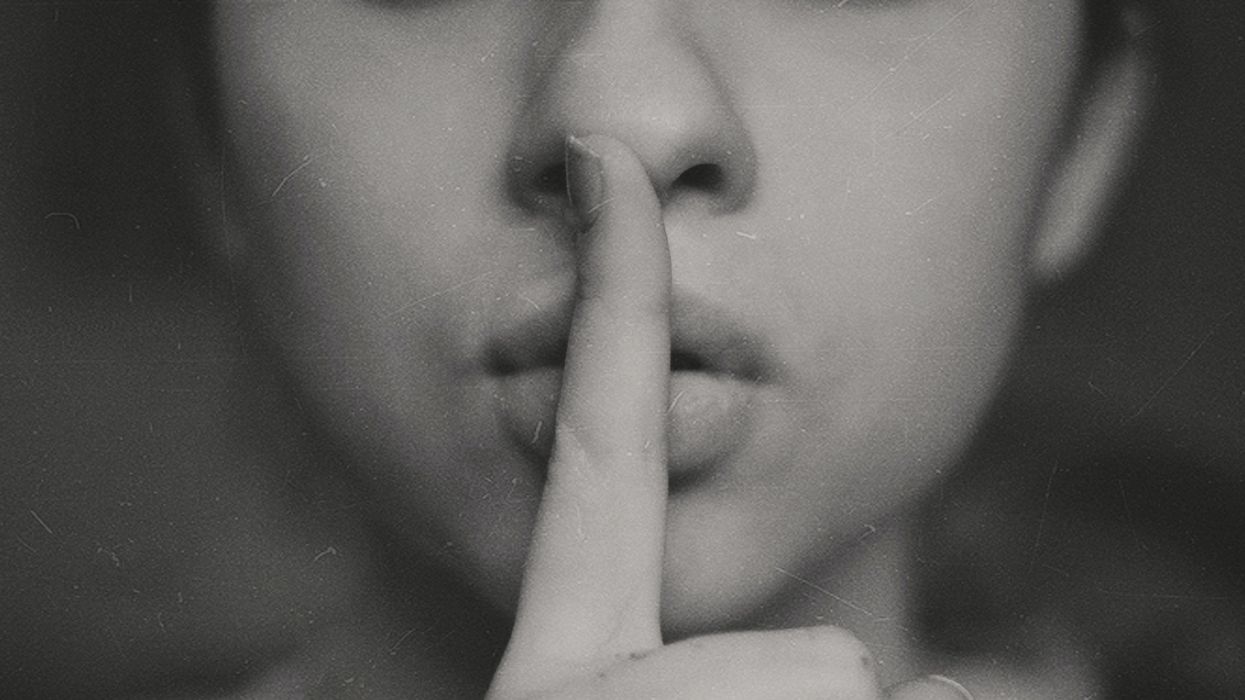 Woman keeping secret by holding finger to lips and whispering, "Shhh"