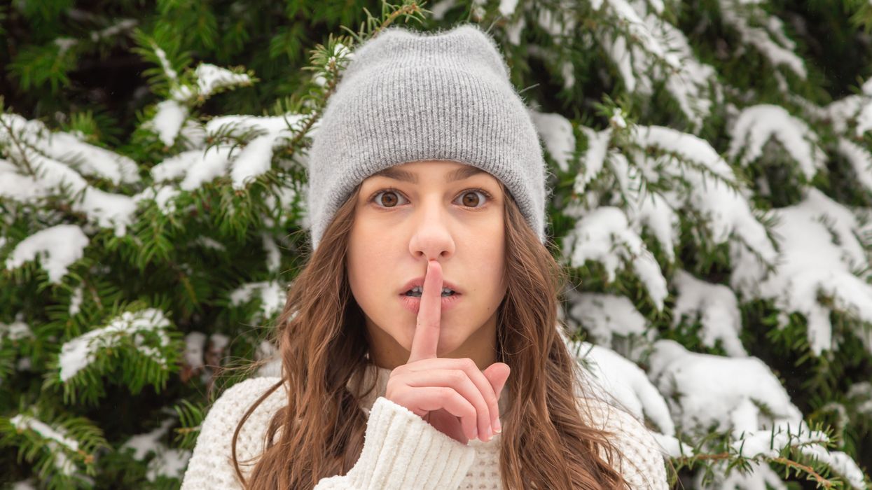 Woman making "shhhh" symbol with finger to lips