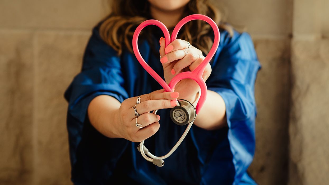 Woman making the shape of a heart with a stethoscope