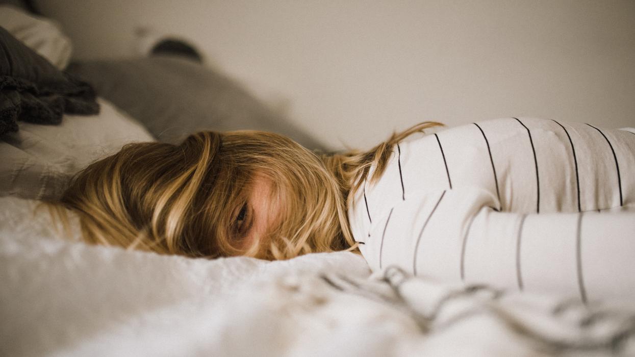 woman on bed peeking through hair