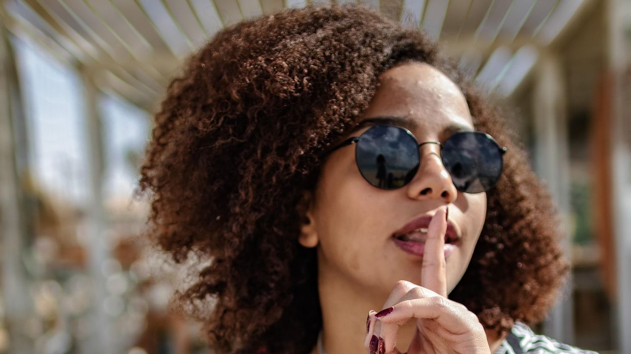 Woman putting finger to mouth in a shushing motion