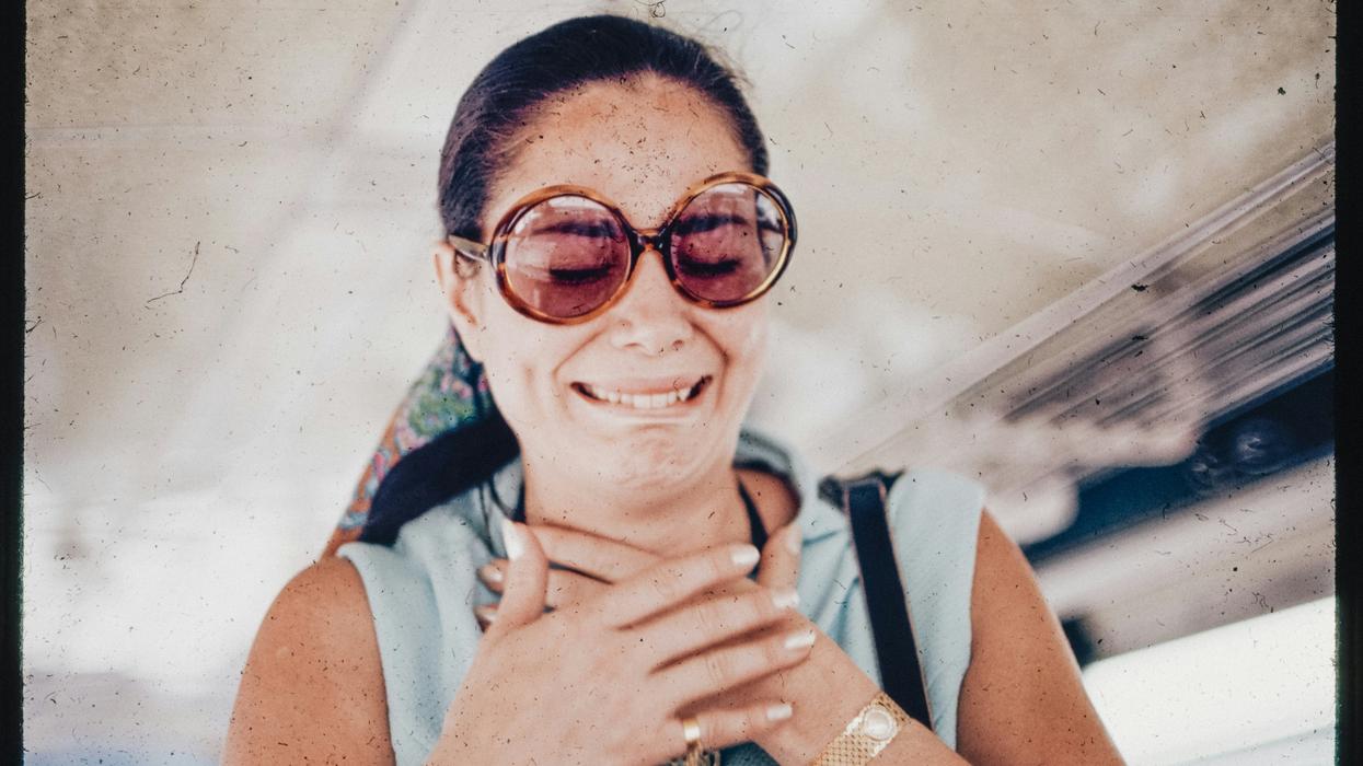 Woman smiling but also visibly cringing