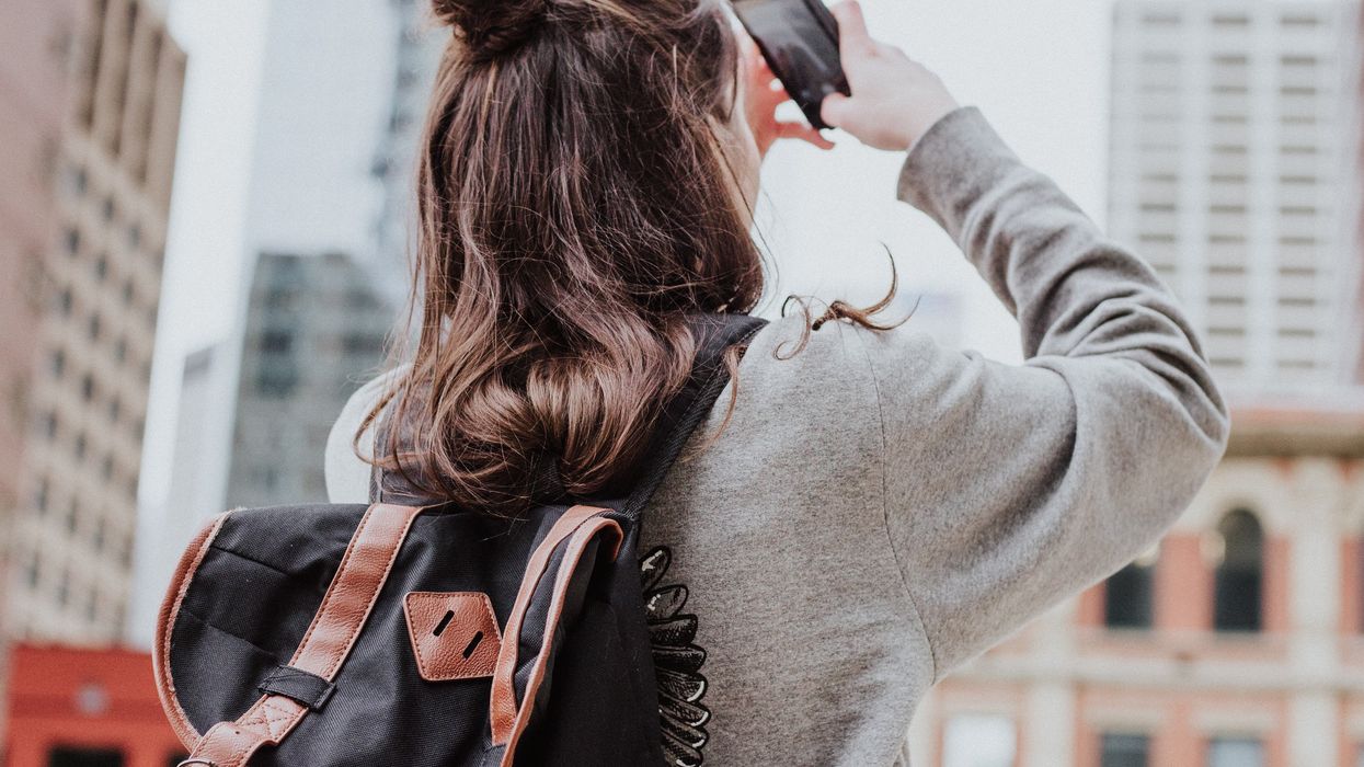 woman taking photo of high-rise building