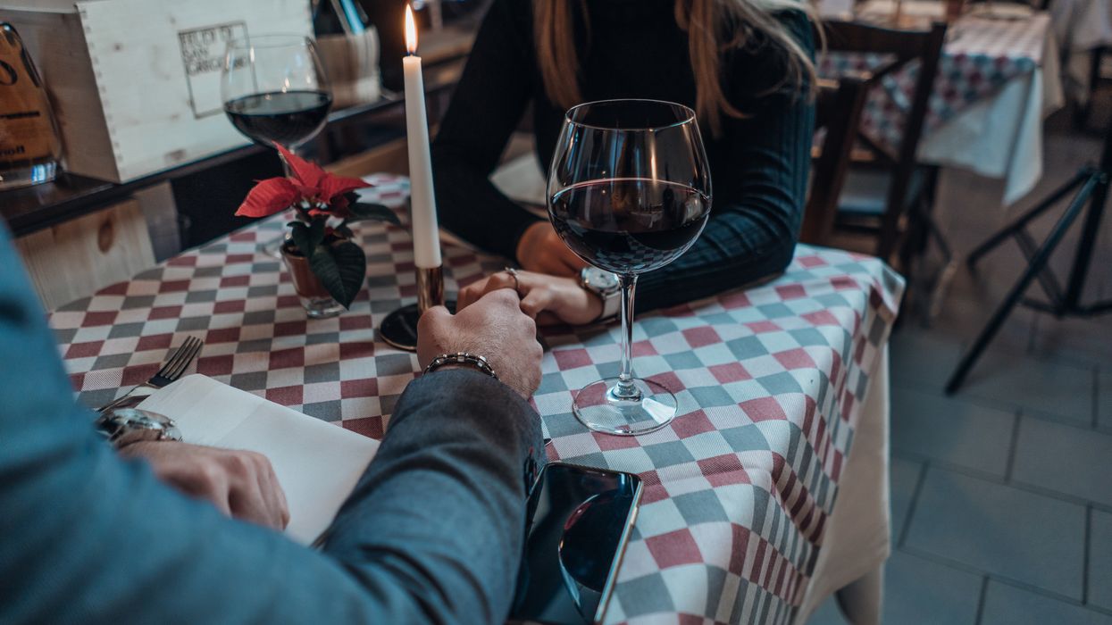 woman wearing black sweater holding hand with man wearing gray suit jacket