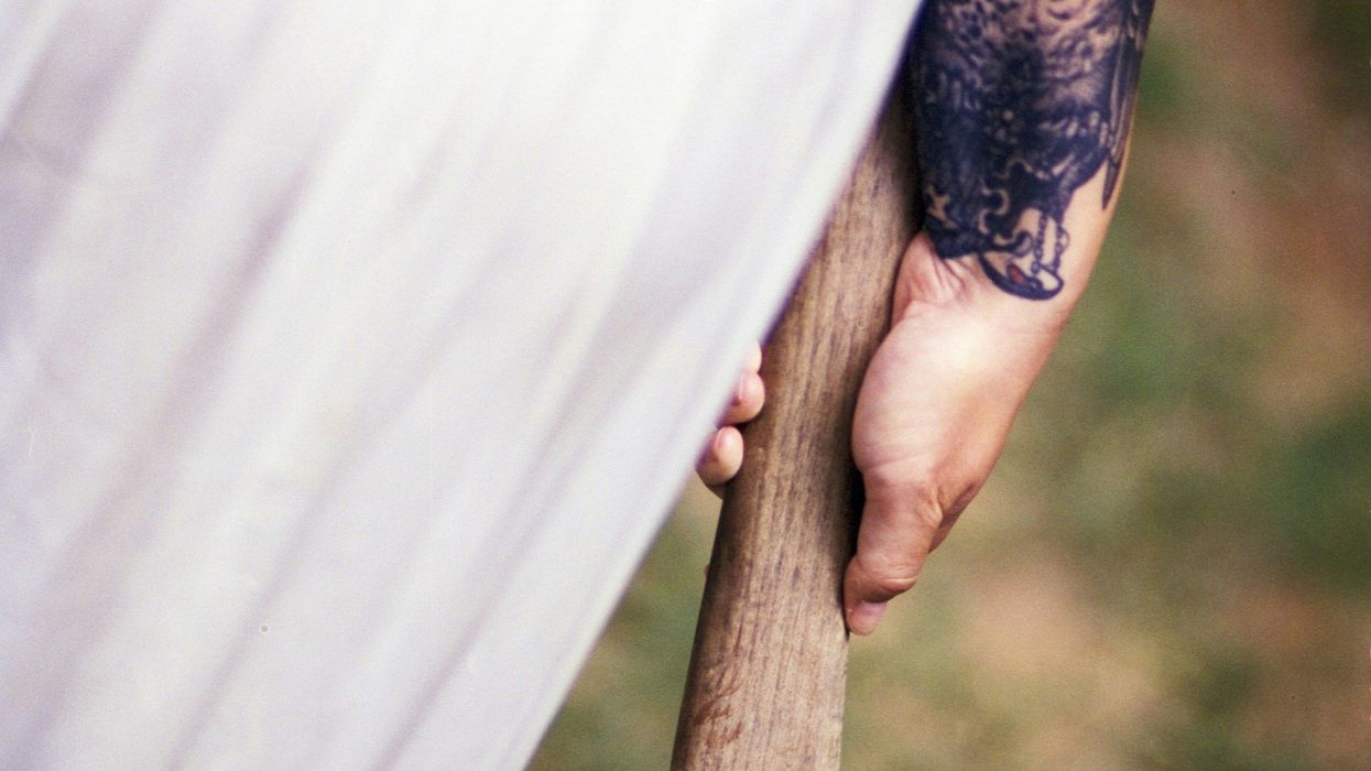 woman wearing white shirt holding axe