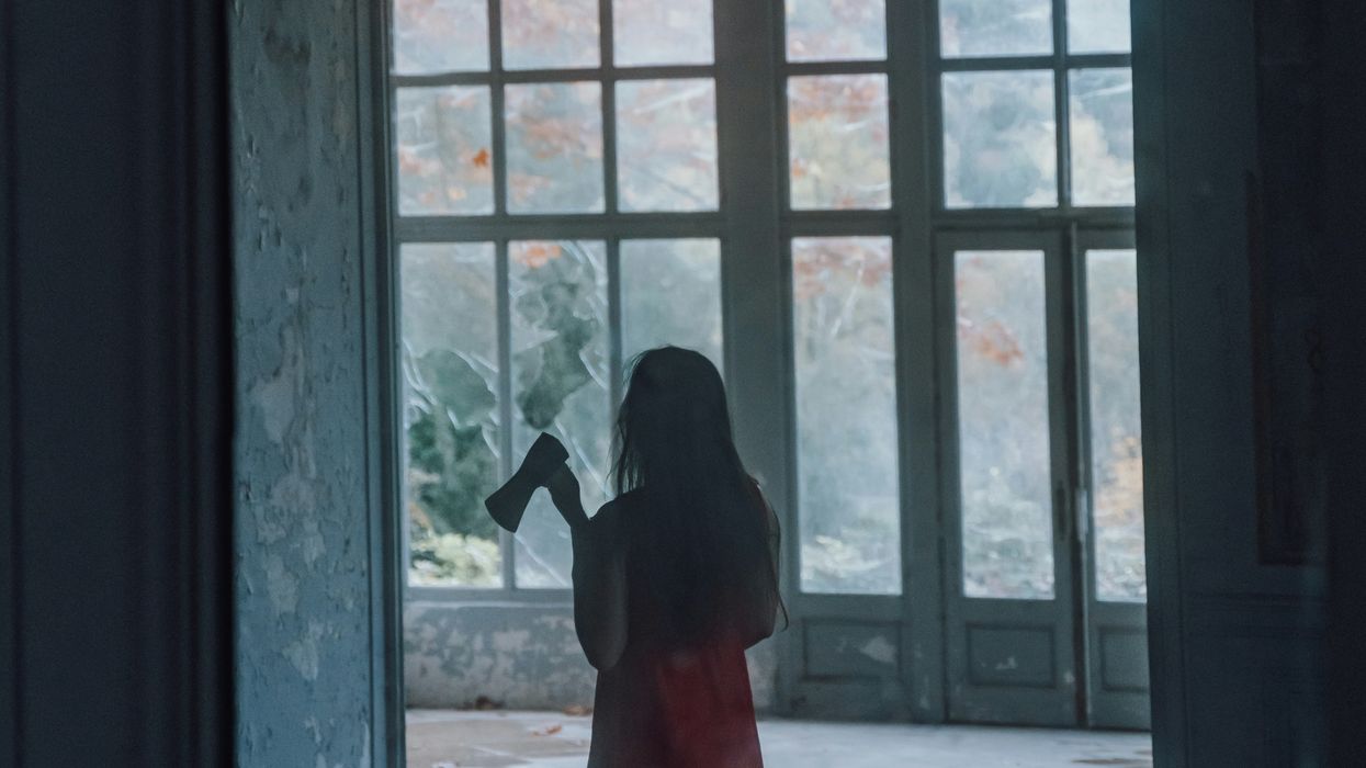Woman with a hatchet roaming around creepy abandoned building