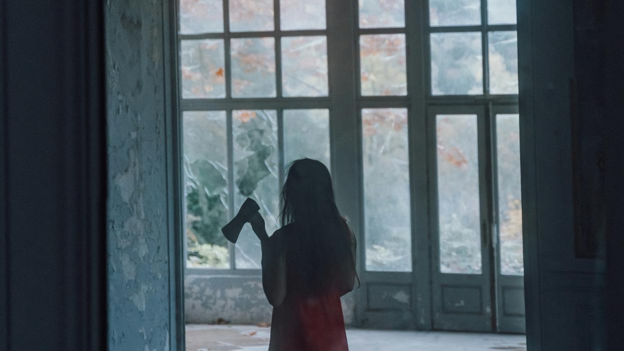 Woman with a hatchet roaming around creepy abandoned building