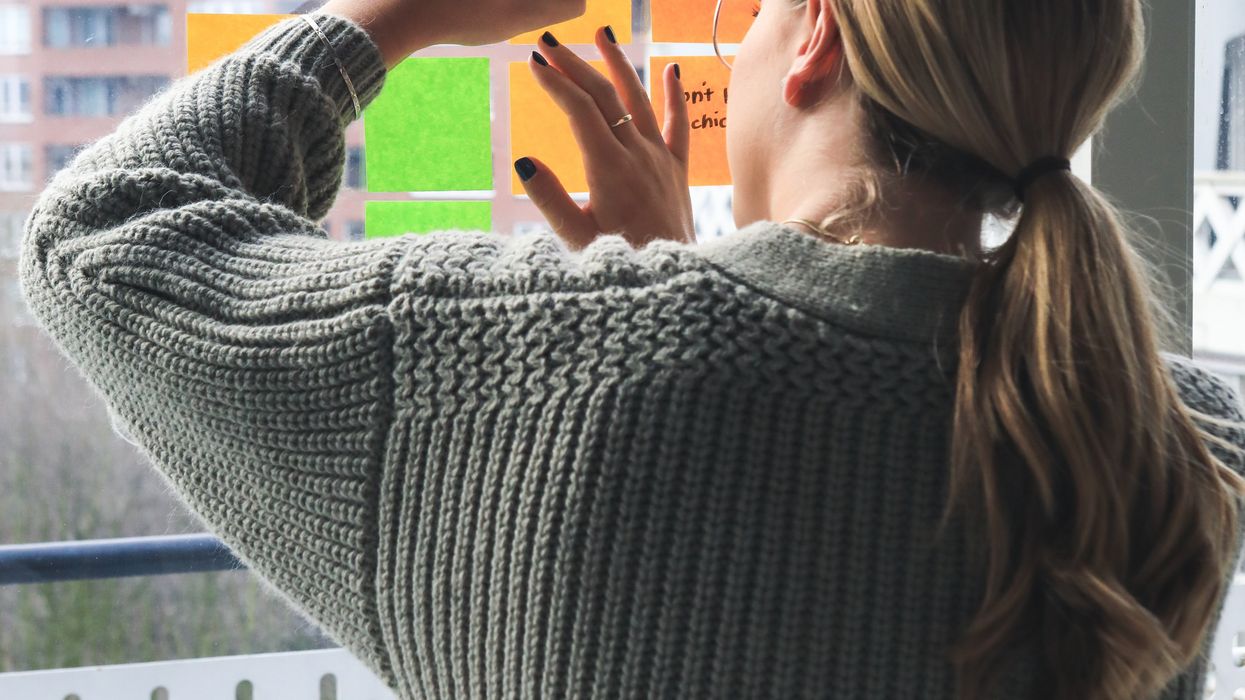 woman writing on notes on window