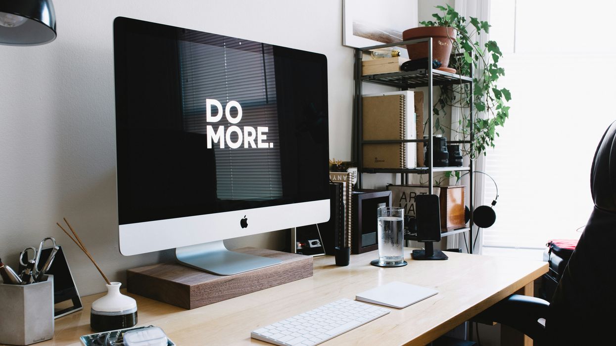Work desk setup with computer that reads, 'Do More' on the screen