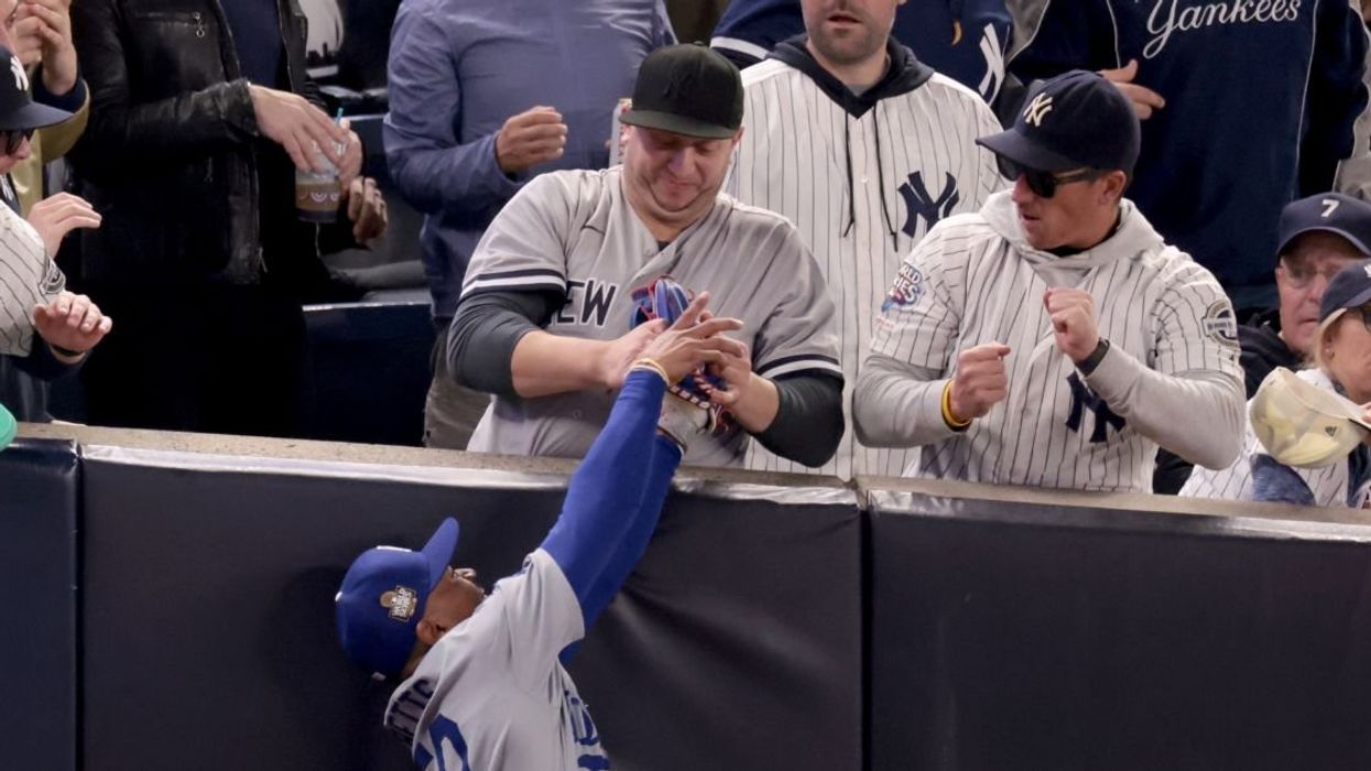 Yankees fan grabbing ball from right fielder Dodgers Mookie Betts' hand