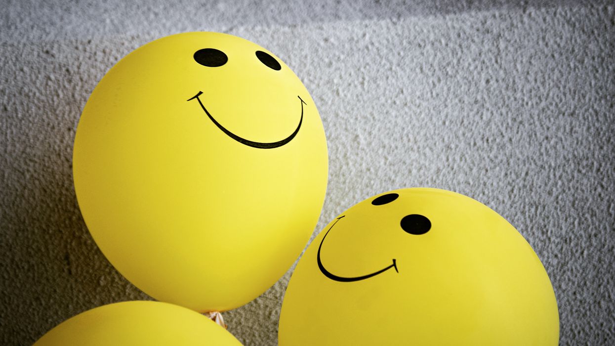 yellow smiley balloon on gray textile