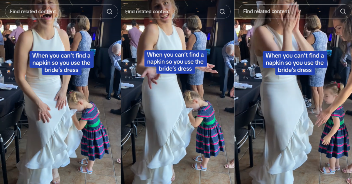 Young girl wiping her face on the bride's dress