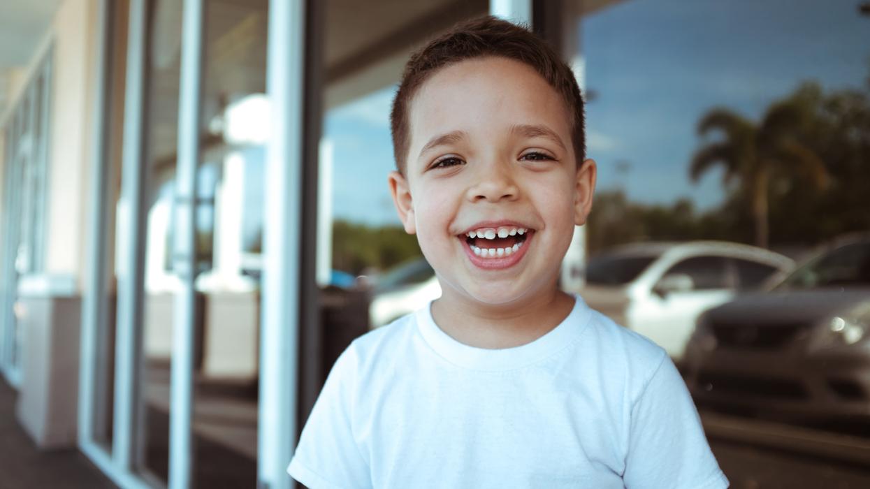 Young kid laughing outside of school