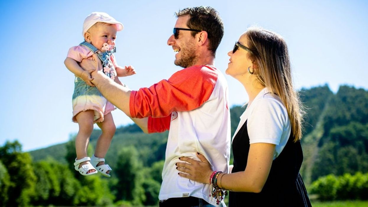 Young parents with dad holding up toddler
